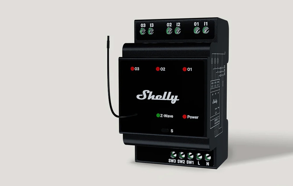 Czarny moduł Shelly z anteną, z widocznymi wskaźnikami LED i portami.