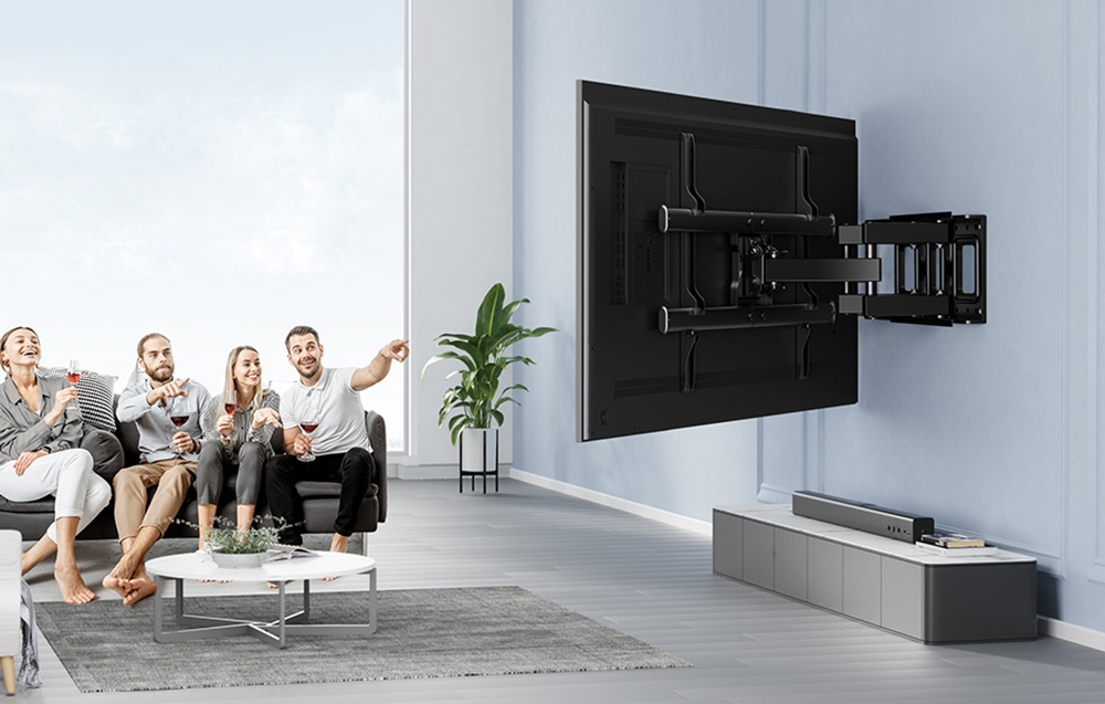 Grupa przyjaciół ogląda telewizor zamontowany na ruchomym uchwycie ściennym w nowoczesnym salonie