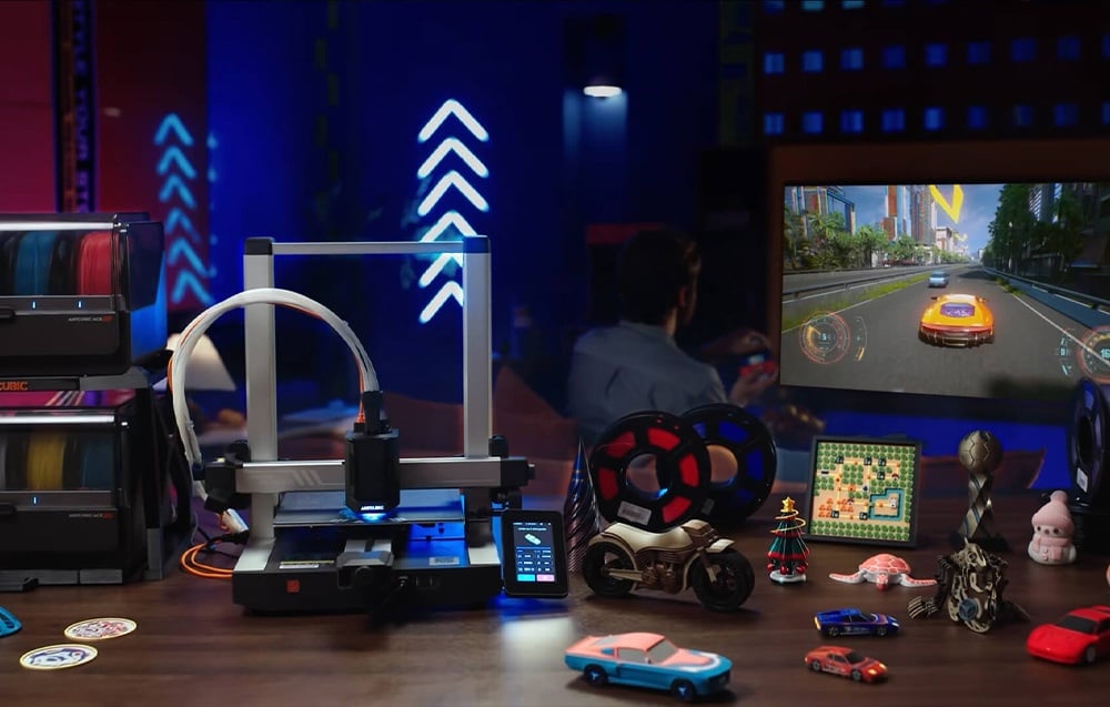 Drukarka Anycubic Kobra 3 V2 stojąca na drewnianym stole razem z modułem ACE Pro i wydrukowanymi modelami 3D.