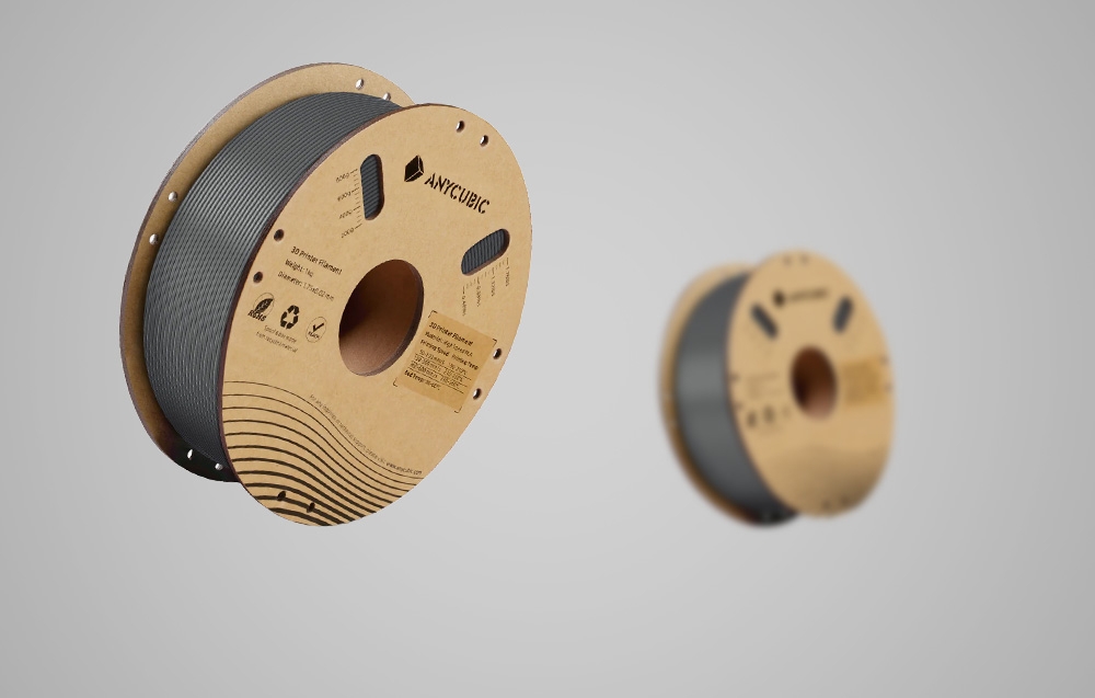 Szary filament PLA Anycubic, w tle znajduje się ten sam produkt.