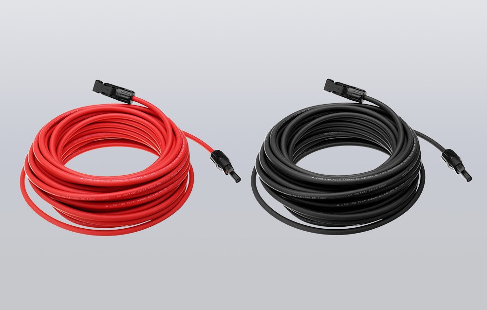 Czerwony i czarny kabel solarny z końcówkami MC4 zwinięte w kółka na szarym tle
