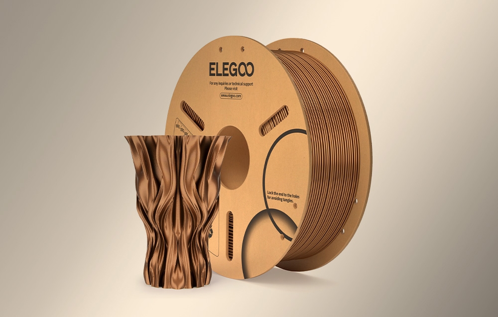 Szpula filamentu 3D ELEGOO w kolorze miedzianym obok eleganckiego wazonu z falistą, spiralną powierzchnią wydrukowanego w tym samym odcieniu