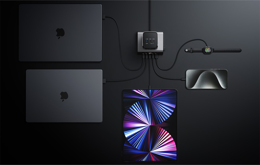dwa laptopy, tablet, smartfon, powerbank i smartwatch ładowane za pomocą stacji dokującej