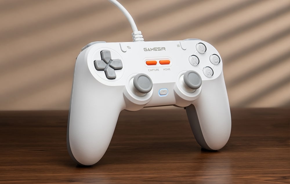 Λευκό χειριστήριο GameSir που στέκεται κατακόρυφα σε ξύλινο τραπέζι με φωτισμό φόντου.