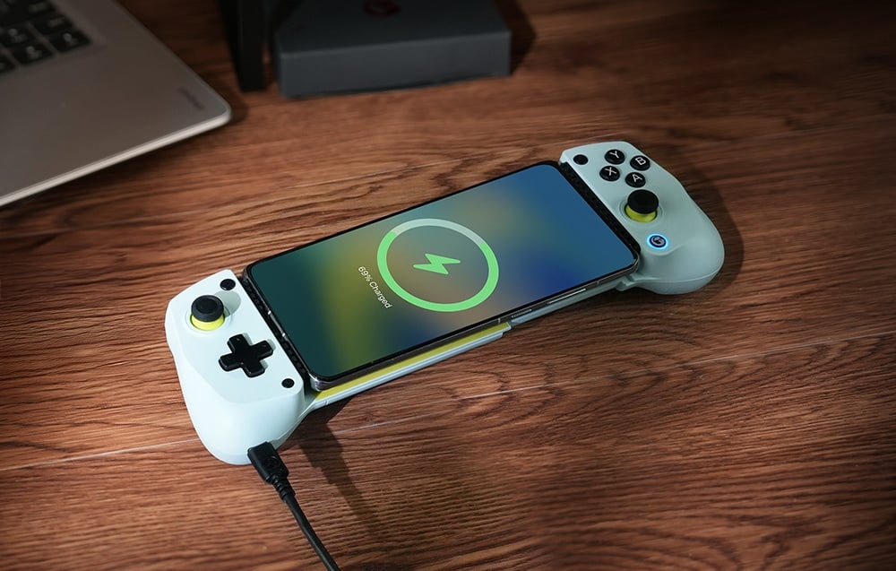 Φόρτιση smartphone σε χειριστήριο GameSir τοποθετημένο σε ξύλινη επιφάνεια.