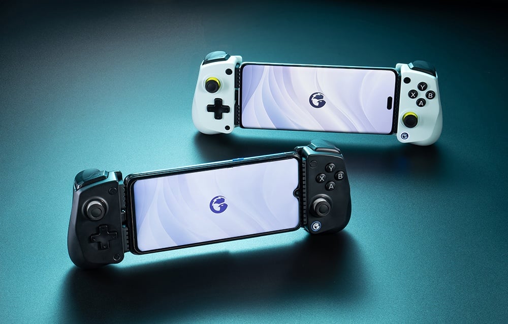 Δύο χειριστήρια GameSir με τοποθετημένα smartphones, λευκό και μαύρο μοντέλο, τοποθετημένα σε μπλε επιφάνεια.