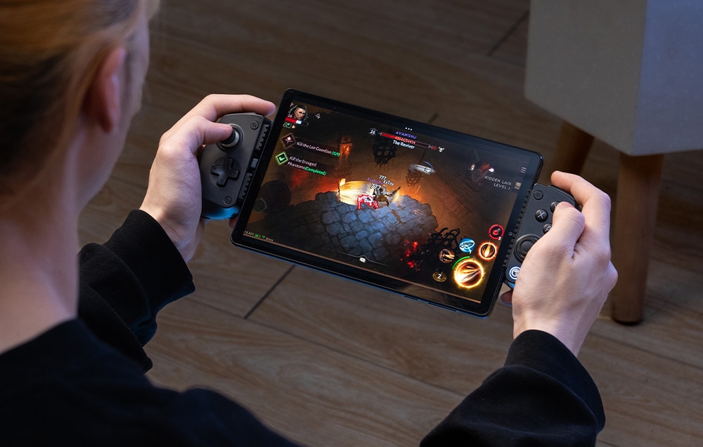 Ένα άτομο κρατάει ένα tablet με ένα μαύρο χειριστήριο GameSir στα πλευρά του κατά τη διάρκεια ενός παιχνιδιού RPG.