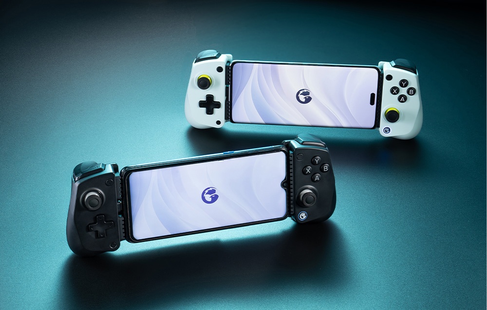 Δύο χειριστήρια GameSir με προσαρτημένα smartphones - ένα λευκό και ένα μαύρο - τοποθετημένα σε μπλε επιφάνεια.