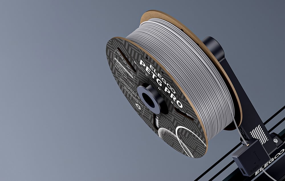 szpula szarego filamentu nałożona na drukarkę 3D