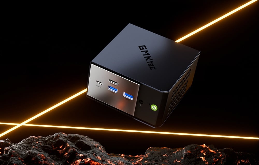 Ένα μαύρο Mini PC GMKtec σε μαύρο και πορτοκαλί φόντο.