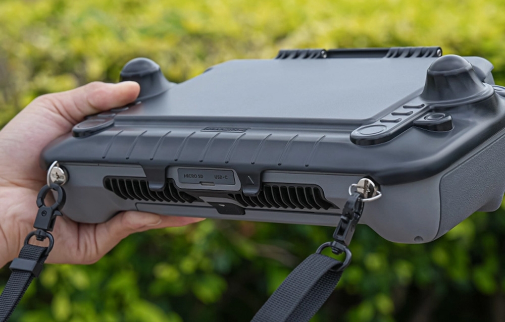 Χέρια που κρατούν χειριστήριο drone με αντηλιακό γείσο, θύρες και ιμάντες ασφαλείας