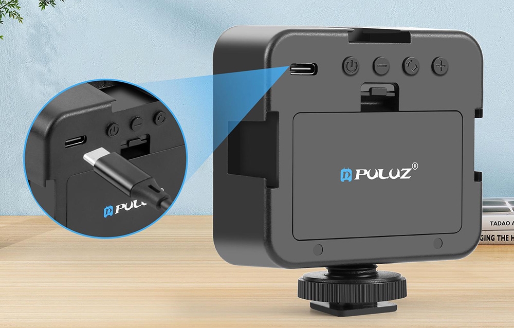 Μια μαύρη συσκευή PULUZ με θύρα USB-C που απεικονίζεται μεγεθυμένη σε ένα ξύλινο γραφείο