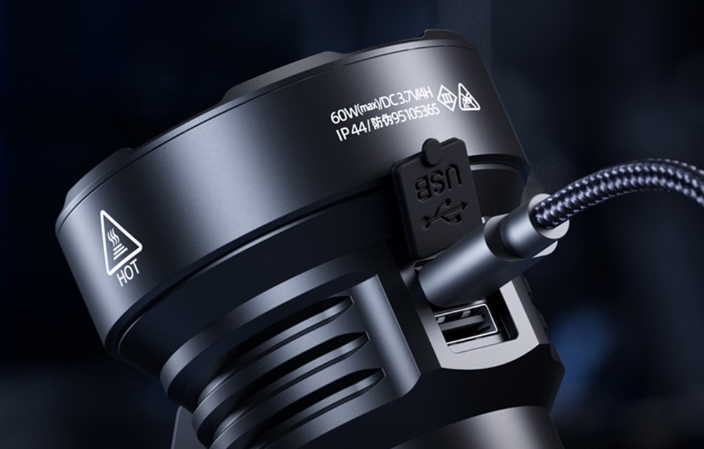 Κοντινό πλάνο ενός μαύρου φακού συνδεδεμένου με καλώδιο φόρτισης σε σκούρο φόντο