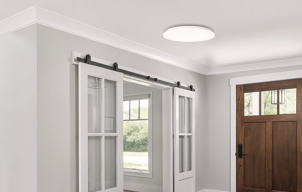 Λαμπτήρας οροφής Yeelight MercuryE C260 τοποθετημένος σε φωτεινό διάδρομο με συρόμενες πόρτες και ξύλινη εξώπορτα.