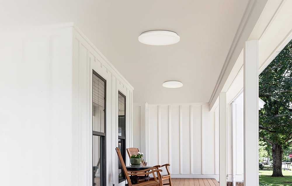 Δύο λαμπτήρες οροφής Yeelight MercuryE C300 τοποθετημένοι σε σκεπαστή βεράντα με ξύλινο δάπεδο και κουνιστή καρέκλα.