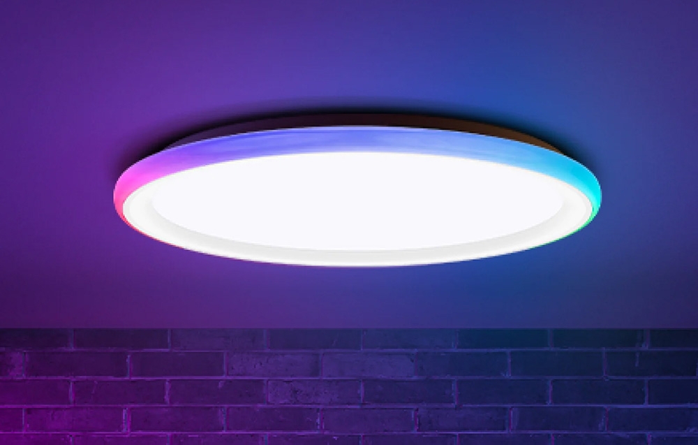 Φωτιστικό οροφής Yeelight Mars C300 που λάμπει με λευκό και έγχρωμο φως σε τοίχο από τούβλα.