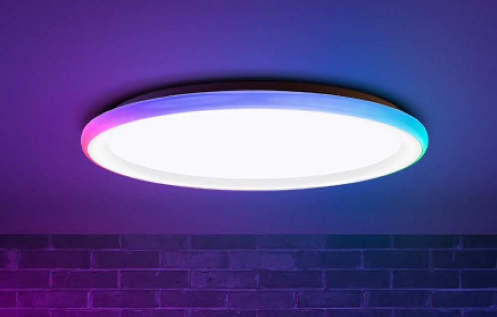 Φωτιστικό οροφής Yeelight Mars C400 που ακτινοβολεί λευκό και έγχρωμο φως σε τοίχο από τούβλα.