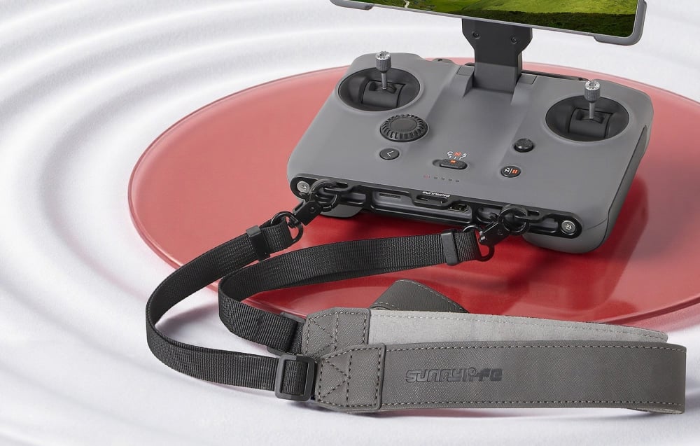 Ελεγκτής drone με τοποθετημένη οθόνη και προσαρτημένο κορδόνι σε κόκκινο τραπέζι