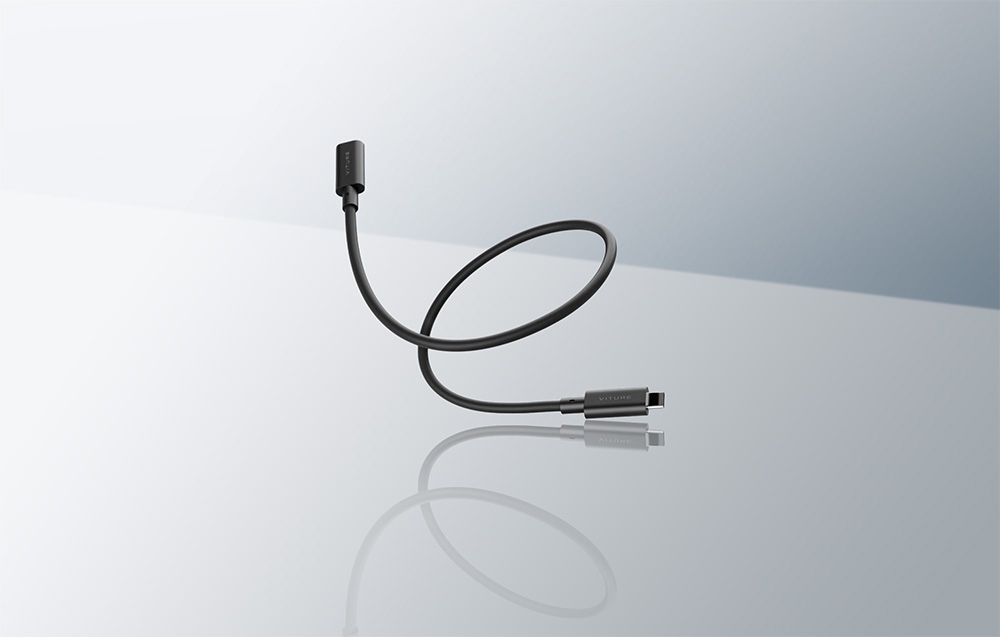 Το μαύρο καλώδιο USB-C του VITURE αιωρείται πάνω από μια κατοπτρική, ανοιχτή γκρι επιφάνεια