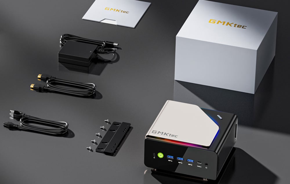 Το Mini PC GMKtec βρίσκεται πάνω σε ένα σκούρο τραπέζι με τα περιεχόμενα του κιτ.