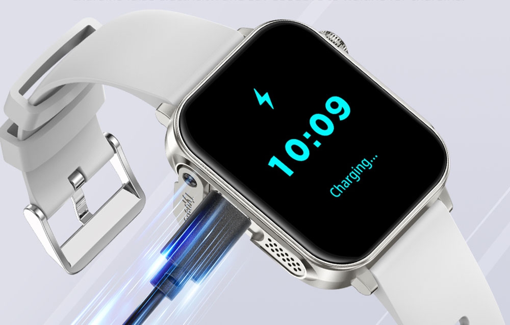Ένα ασημί smartwatch με λευκό λουράκι συνδεδεμένο με φόρτιση.