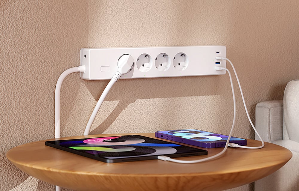 Λευκή λωρίδα τροφοδοσίας με τρεις συνδεδεμένες συσκευές που βρίσκονται πάνω σε ένα στρογγυλό τραπέζι, συμπεριλαμβανομένου ενός τηλεφώνου και ενός tablet