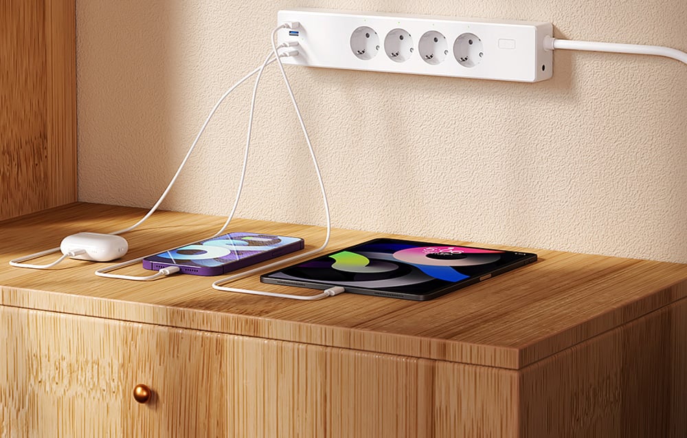 Λωρίδα τροφοδοσίας με συνδεδεμένα ακουστικά, smartphone και tablet που βρίσκονται πάνω σε ένα ανοιχτόχρωμο ξύλινο τραπέζι