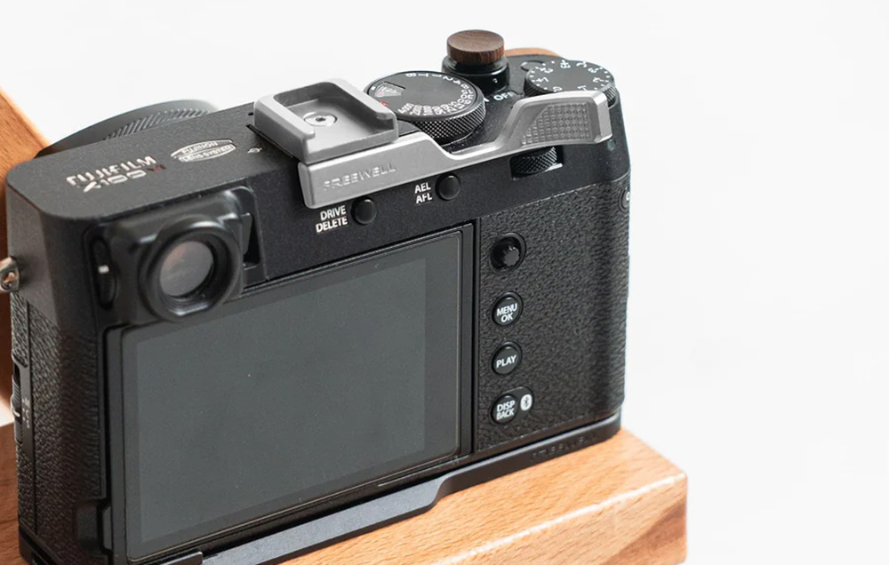 Φωτογραφική μηχανή Fuji Film με ασημί βάση Freewell σε ξύλινο τραπέζι.