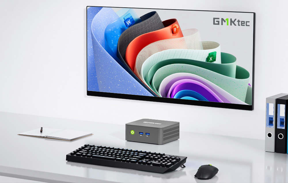 Μίνι υπολογιστής GMKtec πάνω σε γραφείο με οθόνη που εμφανίζει εφαρμογές Microsoft Office και πληκτρολόγιο και ποντίκι