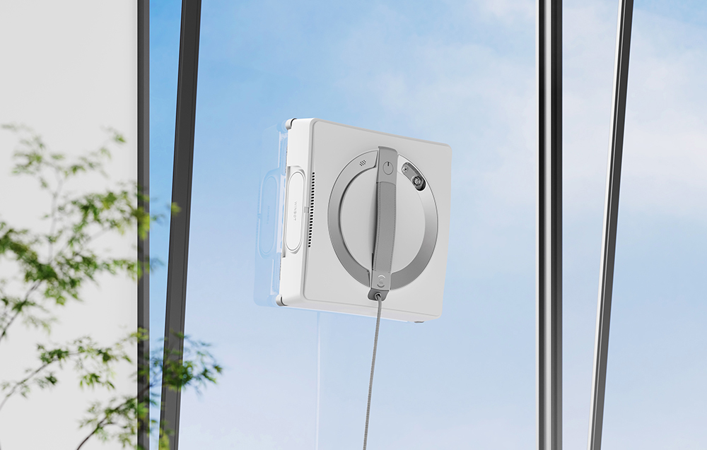 Το ρομπότ W2 Pro Omni πλένει το τζάμι του παραθύρου, στα αριστερά βρίσκεται ένα φυτό