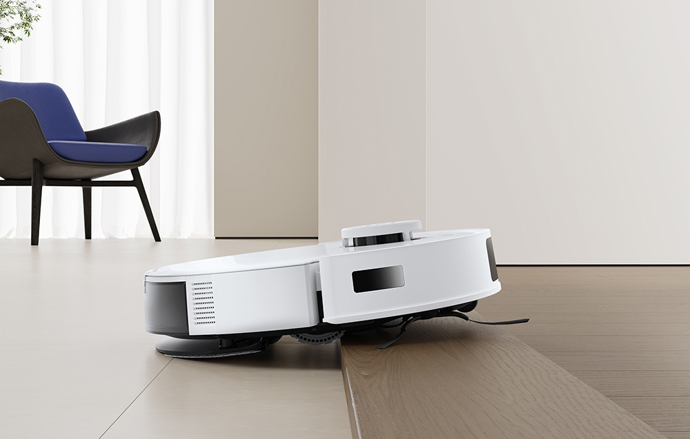 Ρομπότ καθαρισμού Ecovacs N20 που περνάει το κατώφλι, με φόντο μια μπλε καρέκλα