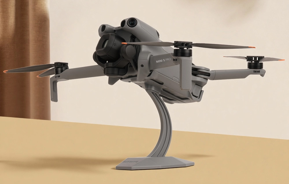 DJI Mini 5 Pro drone τοποθετημένο σε βάση πάνω σε πάγκο σε φωτεινό δωμάτιο