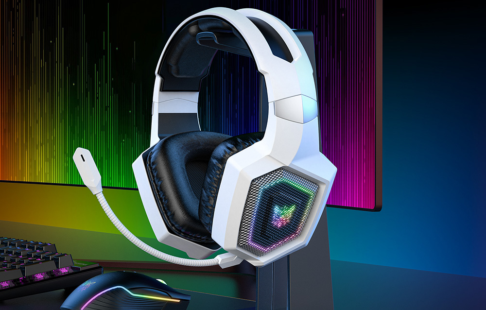 Λευκά ακουστικά gaming κρεμασμένα σε βραχίονα δίπλα σε οθόνη, πληκτρολόγιο και ποντίκι