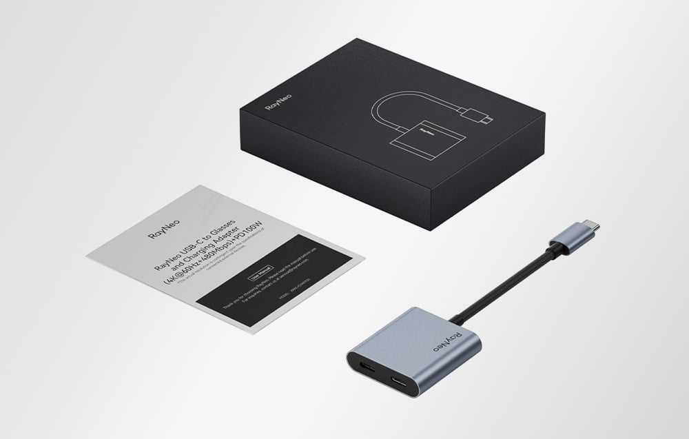 Προσαρμογέας RayNeo USB-C με καλώδιο και οδηγίες χρήσης δίπλα στη συσκευασία, σε φωτεινό φόντο.