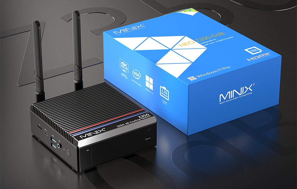 Mini PC Minix σε γκρι φόντο, δίπλα σε μπλε κουτί προϊόντος.