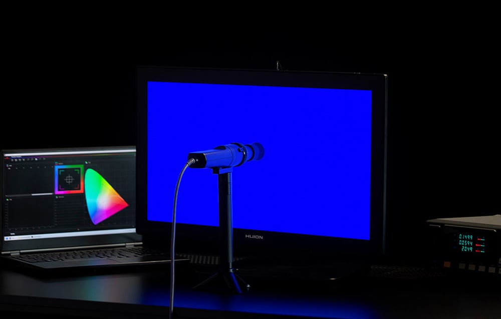 Τablet γραφικών με μπλε φωτισμένη οθόνη, τοποθετημένο δίπλα σε φορητό υπολογιστή με πρόγραμμα γραφικών που εκτελείται.