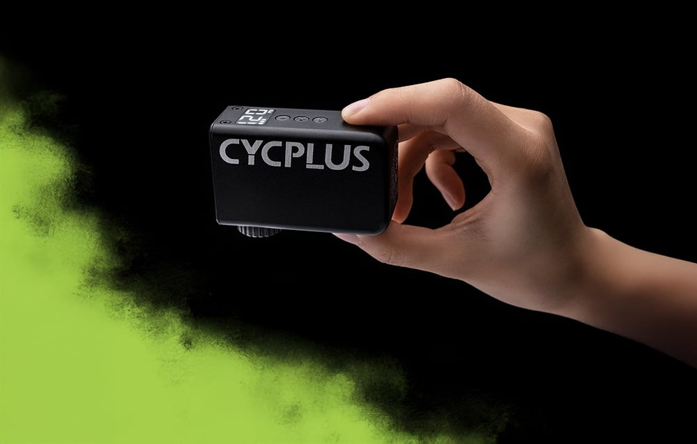 Χέρι που κρατάει μαύρη αντλία Cycplus με λευκό λογότυπο σε μαύρο φόντο με πράσινη προφορά