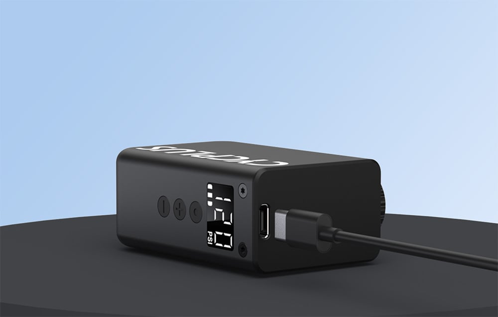 Μαύρη αντλία Cycplus με οθόνη, κουμπιά και καλώδιο USB συνδεδεμένο στη θύρα φόρτισης