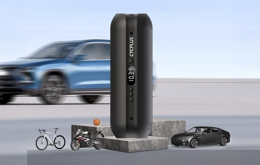 Ηλεκτρική αντλία Cycplus AL1 που στέκεται όρθια σε κύβους από σκυρόδεμα με φόντο ένα ασαφές αυτοκίνητο