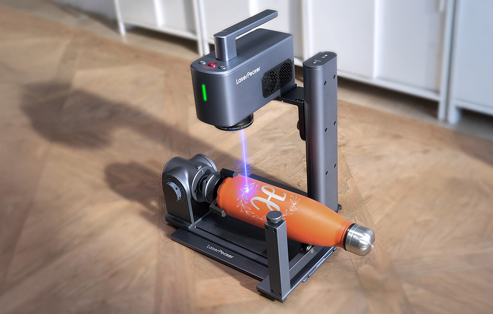 LaserPecker LP2 Plus λέιζερ χάραξης που χαράζει ένα περιστρεφόμενο μεταλλικό μπουκάλι.