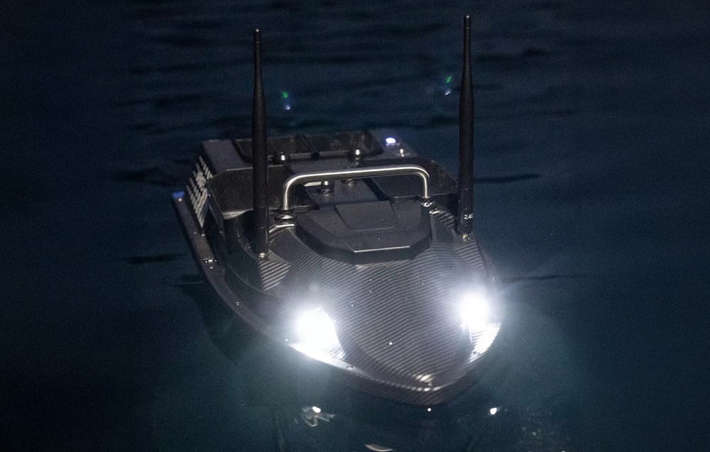 Σκάφος δόλωμα που επιπλέει στο νερό τη νύχτα, με τα μπροστινά φώτα αναμμένα