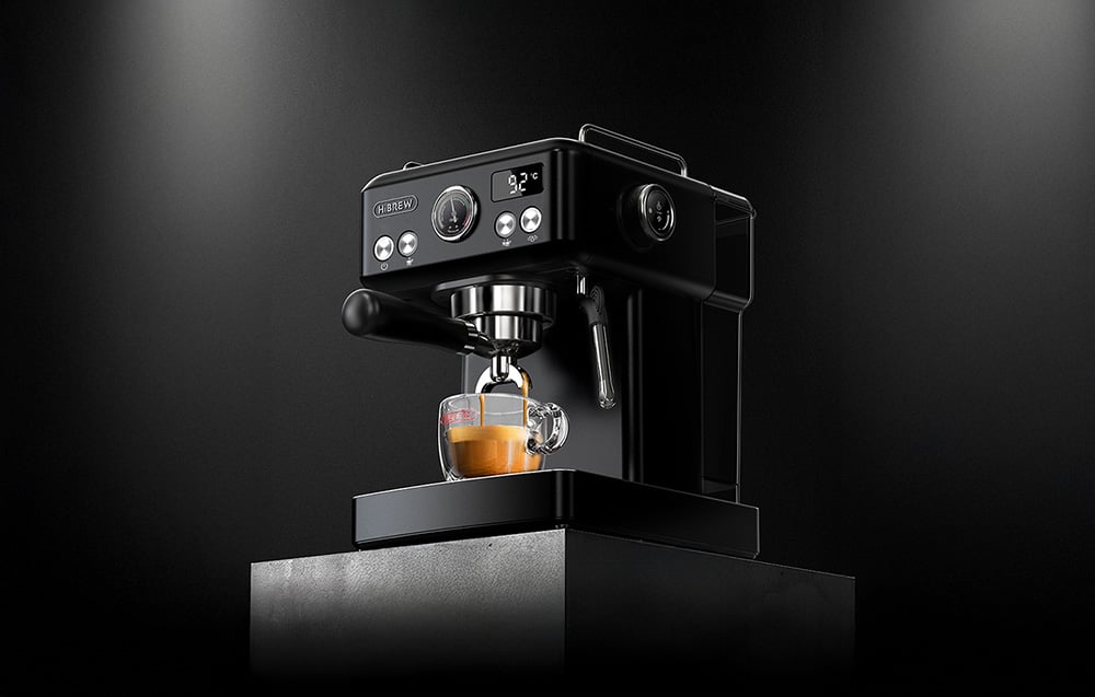 Μαύρη καφετιέρα HiBREW με έμβολο σε σκούρο φόντο, που δείχνει τον φωτιζόμενο πίνακα ελέγχου, την ένδειξη θερμοκρασίας και τη διαδικασία παρασκευής εσπρέσο σε γυάλινο φλιτζάνι.