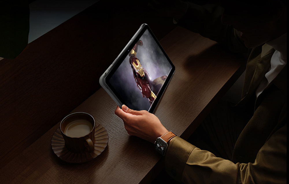 Άτομο που κρατά tablet στο χέρι, με φλιτζάνι καφέ δίπλα του