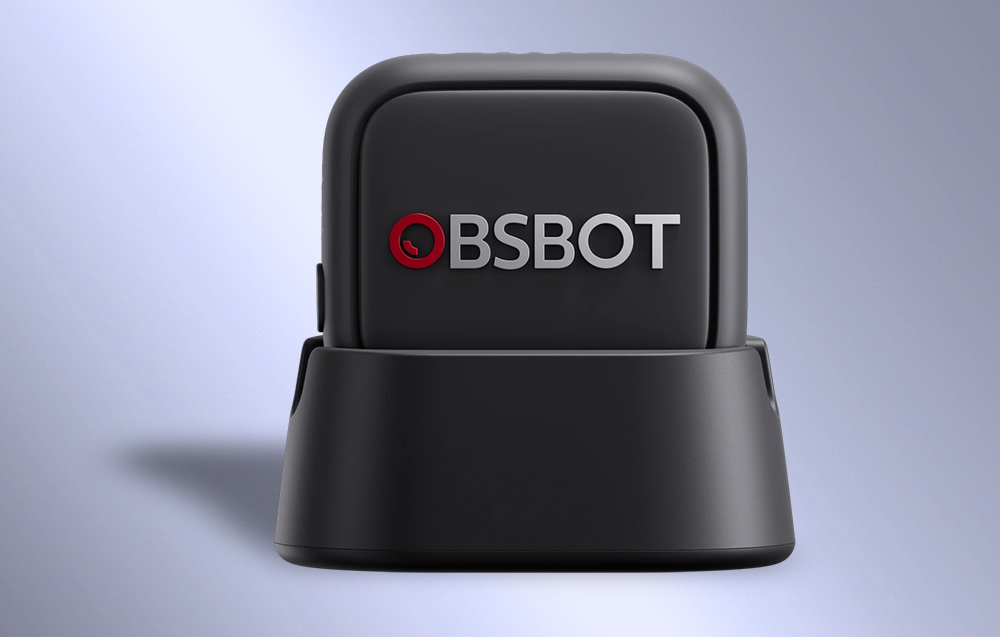 Μικρόφωνο OBSBOT σε μαύρη θήκη τοποθετημένο σε βάση φόρτισης με ορατό λογότυπο στο μπροστινό πάνελ