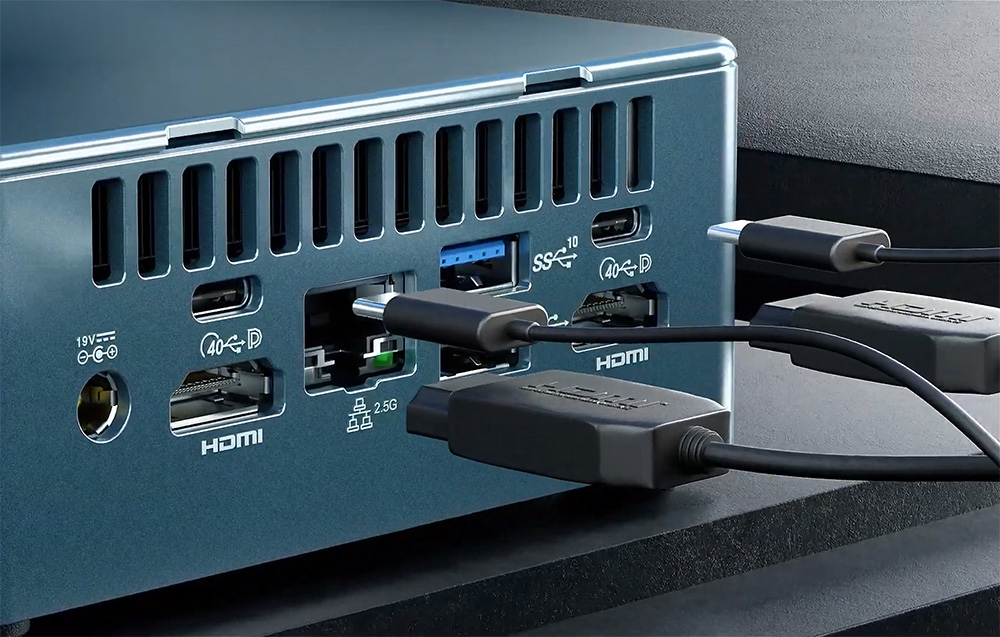Καλώδια σύνδεσης από τις θύρες του MINI PC, το οποίο βρίσκεται πάνω σε ένα σκούρο γραφείο