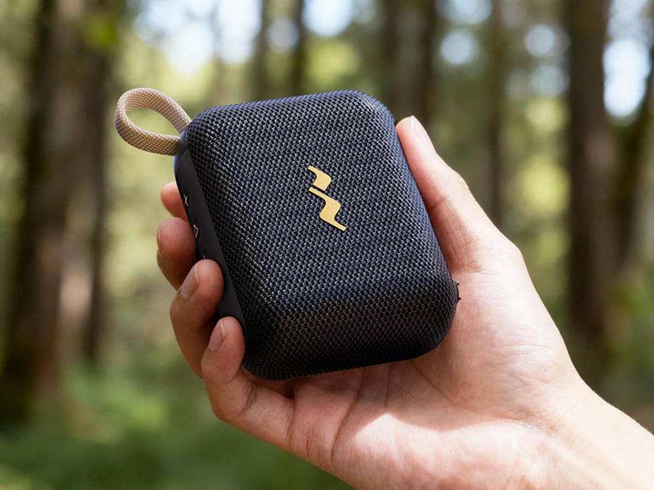 Φορητό ηχείο Bluetooth που κρατιέται στο χέρι με φόντο ένα δάσος