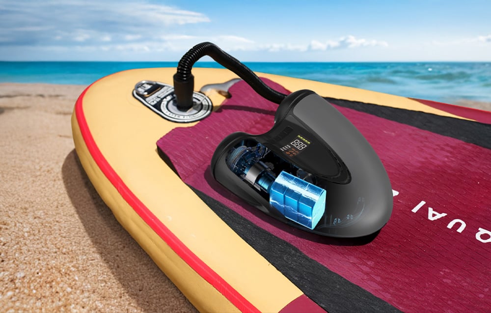 Η Flextail Evo SUP Pump Pro φουσκώνει μια σανίδα SUP στην παραλία.