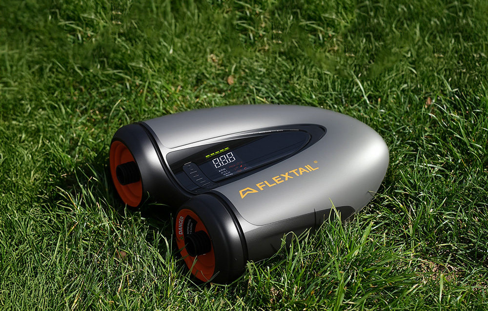 Η Flextail Evo SUP Pump Pro βρίσκεται στο γρασίδι με την οθόνη της ορατή.