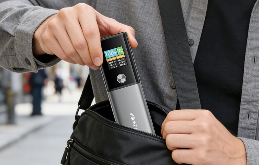 Άνδρας που τοποθετεί ένα power bank σε μαύρη τσάντα ώμου