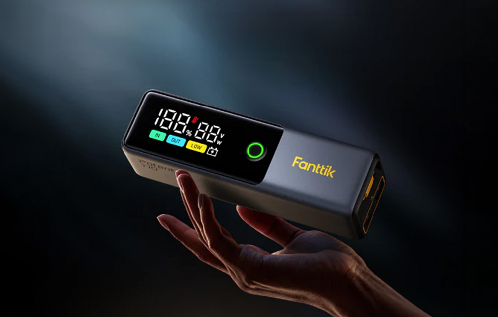 Το Fanttik jump starter κρατημένο στο χέρι, με την οθόνη ορατή σε σκούρο φόντο